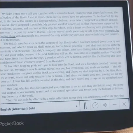 Layar e-reader PocketBook menampilkan halaman teks buku dengan panel text-to-speech di bawah