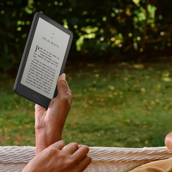 Tangan memegang Kindle Paperwhite di hammock